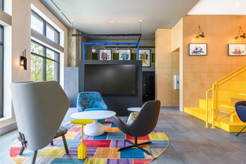 A living room with chairs and a television    and a staircase
